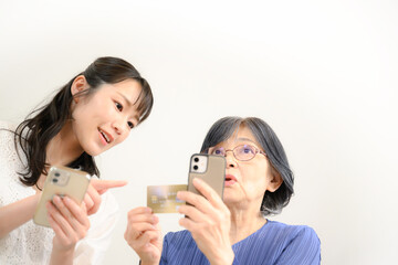 母にクレジットカードの登録の仕方を教える娘　コピースペースあり