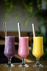 organic mixed fresh fruit smoothie glasses on cafe table