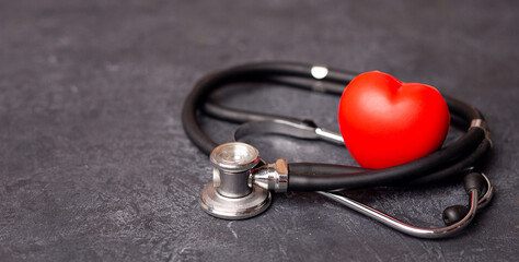 Red heart with stethoscope on dark background, heart health, health insurance concept, World heart...