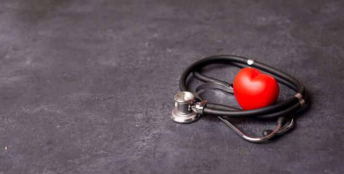 Red heart with stethoscope on dark background, heart health, health insurance concept, World heart day, world health day, doctor day, world hypertension day. Copy space
