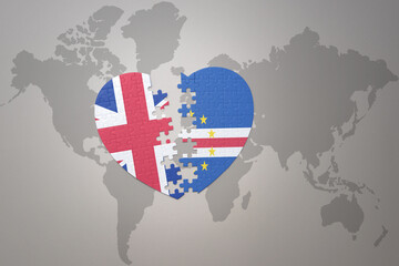 puzzle heart with the national flag of cape verde and great britain on a world map background. Concept.