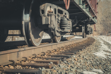 A railway freight wagon stands on an alternate track. The lower part of the car with a close-up of the wheelset. Cargo wagon. Iron wheel. Selective focus