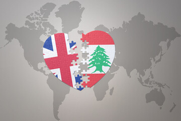 puzzle heart with the national flag of lebanon and great britain on a world map background. Concept.