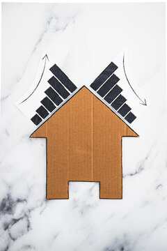 mortgages rentals and property prices increasing and decreasing, house icon made of cardboard with graph showing stats going up and down
