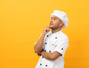 Young handsome asian man chef in uniform standing looking at blank space and thinking menu on...