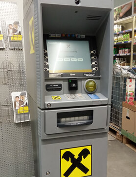 Raiffeisen Bank ATMs in Metro Cash & Carry store. Close-up of monitor and keyboard. On walls of ATM, painted in corporate gray, tlogo of Raiffeisen Bank is placed. Krasnodar, Russia - May 19, 2022.