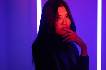 Stylish sexy woman in trendy. Beautiful young asian woman standing pose with neon light. Asia...