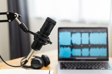 Condenser microphone in recording home studio. Content creator working with laptop host streaming radio podcast interview conversation at home broadcast studio recording waveform voice over radio