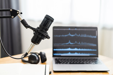 Condenser microphone in recording home studio. Content creator working with laptop host streaming radio podcast interview conversation at home broadcast studio recording waveform voice over radio