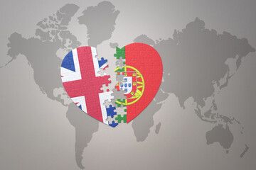 puzzle heart with the national flag of portugal and great britain on a world map background. Concept.