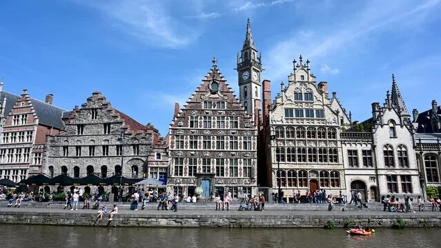 Ghent, Belgium: Beautiful medieval buildings in city centre. Tourists on the streets. Boats on canal. Ghent, popular tourist destination. 