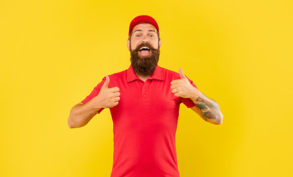 Happy bearded man in casual red cap and tshirt giving double thumbs yellow background, deliveryman