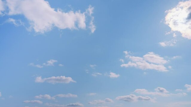 晴天の空、雲の間を飛んでいく飛行機　4K　UHD