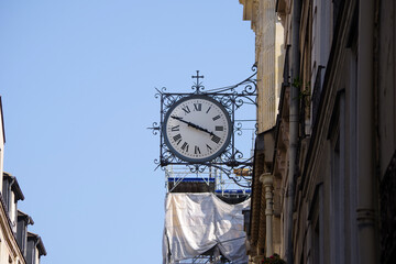 Fototapeta na wymiar Horloge parisienne au-dessus d'un bâtiment en travaux
