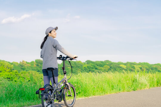 ミニベロでサイクリングする女性　小径自転車　折り畳み自転車