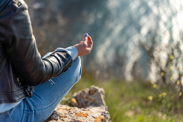 yoga, gesture and healthy lifestyle concept - hand of meditating yogi woman showing gyan mudra over...