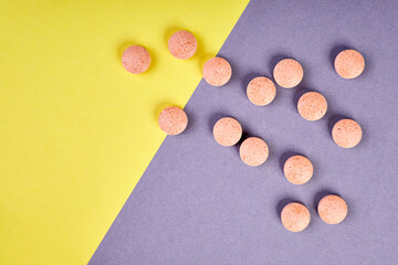 Orange pills on colorful background