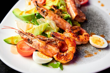 Salad with avocado, tiger prawns, tomatoes and quail eggs