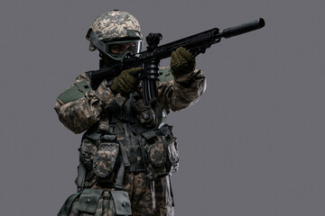 Photo of professional servicewoman aiming rifle dressed in camouflage uniform.