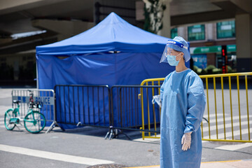 Medical worker in protective suits and surgical face masks on the street. City blockade.