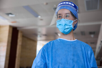 Fototapeta na wymiar Close up view of a doctor inside hospital wearing surgical mask and a face shield.