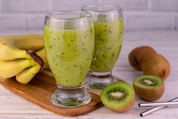 Kiwi and banana smoothie in tall glasses.
