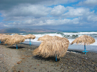 Storm on the beach, tourist resort, beach umbrellas, strong wind