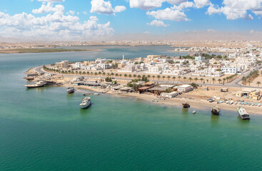Fototapeta na wymiar Sur, Oman - an important point for sailors and famous also for its building wooden ships, Sur is a pearl of Oman, with its fusion of green waters, white buildings and red rocks