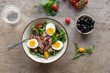 Nicoise french composed salad with canned tuna, anchovy, hard-boiled eggs, tomatoes, and black olives. A delicious meal for summer, dinner, keto diet. 