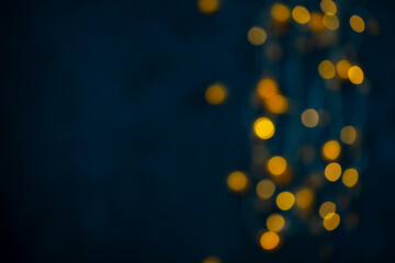 Lights garland blurred, bokeh effect. Dark blue background. Copy space.