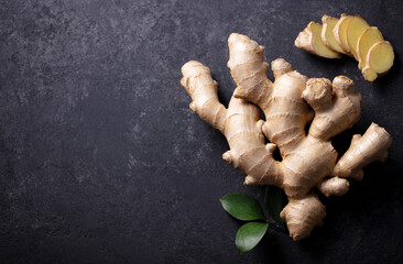 Fresh ginger root with slices. Dark background. Copy space. Top view. - 506593904
