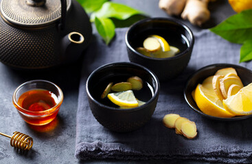 Ginger tea with lemon and honey. Grey background. Close up.