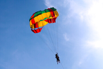 Parasailing in blue sky. Sports, active leisure, travel, vacation concept
