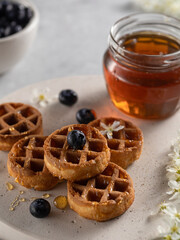 homemade belgian waffels with blueberry and honey on marble table. Vertical