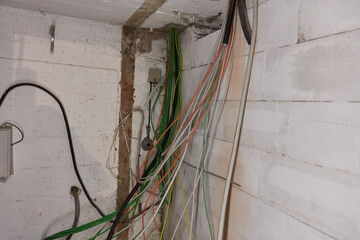 Lots of cables from electrical installation in room in basement