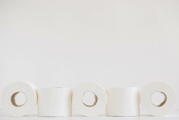 Rolls of white toilet paper on a white background