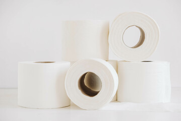 Rolls of white toilet paper on a white background