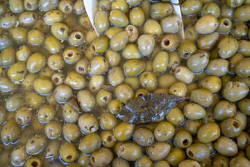 Green marinated olives texture background.