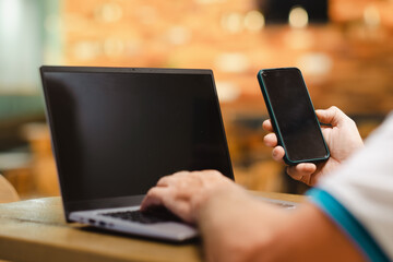 Unrecognizable mature people man traveler wait at the airport gate for delay flight using modern technology device as phone and laptop computer surfing the net