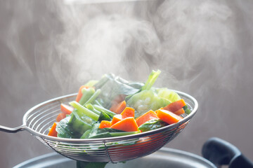 The steam from the vegetable colander in the dark