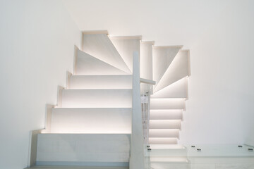 Illuminated wooden staircase in duplex apartment