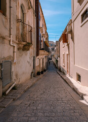 Fototapeta na wymiar Alley in the historic center of Scicli with man walking
