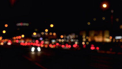 Abstract bokeh background of night street with car and street lamps
