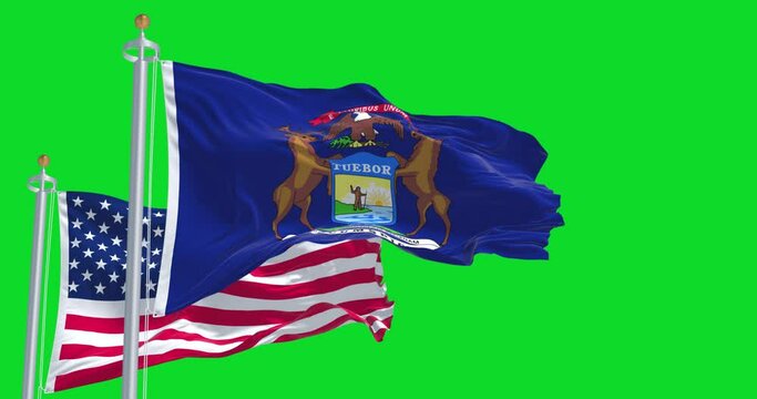 The Michigan state flag waving along with the national flag of the United States of America isolated on a green background