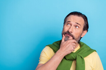 Portrait of minded person arm chin look interested empty space isolated on blue color background