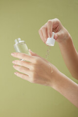 Front view of hand model using cosmetic in green background