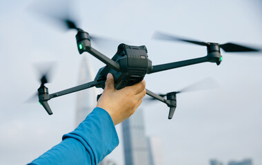 Hand hold a drone for landing in modern city