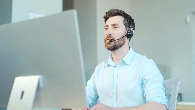 Corporate operator working in customer support service on helpline telesales. Focused man representative call center agent in wireless headset helping client with complaints using computer in office