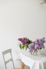 Home interior decor, bouquet of lilacs in a vase on table