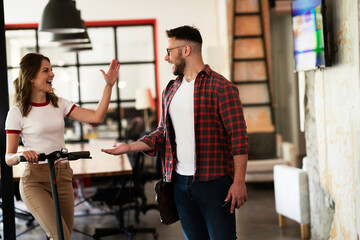 Young businessman and businesswoman in the office. Two friends talking together..